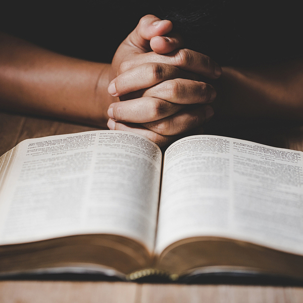 betende Hände vor einer Bibel